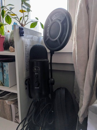 Mon micro, son filtre anti pop, rangés sur mon bureau.