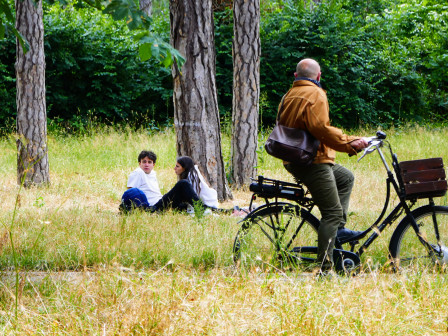 Un homme à vélo semble se tourner vers un jeune couple de pique-niqueurs. En réalité il appelle son chien qui n'a jamais accepté d'être dans le cadre, mais il n'y a que moi qui le sait !