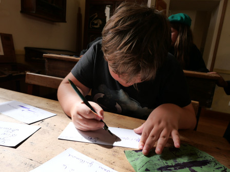 Lomalarchovitch dans une tentative salissante d'écrire à la plume au musée de l'école, cet été.
