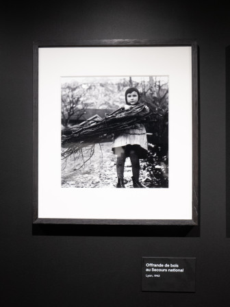 Une petite fille porte une brassée de bois pour une collecte solidaire du côté de Lyon, en 1942.