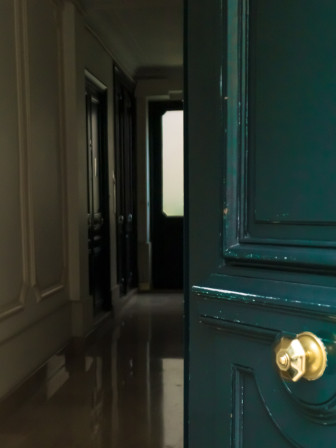 La porte entrouverte d'un immeuble parisien.