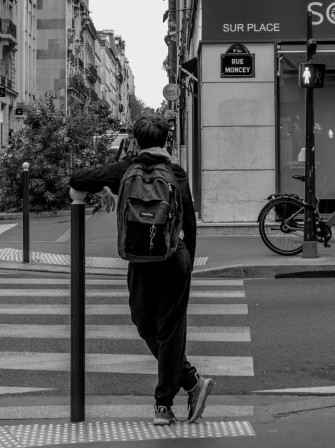 Un garçon attend au coin de la rue de Clichy et de la rue Montcey (aucun rapport avec les hommes croisés ce matin).