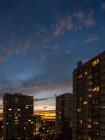 De l'orange de rayons de soleil et de fenêtres allumées dans les immeubles voisins, du bleu pâle au plus foncé dans le ciel, des ombres de nuages et des encore blanc, comme scintillants d'un peu de lumière. Vue par ma fenêtre à la tombée du jour un soir de septembre.