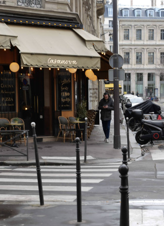 Un homme le nez sur son téléphone longe le restaurant "Le Casanova"