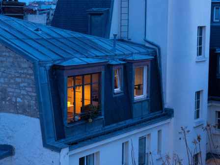 Les lumières de Paris comme points orangés chaleureux dans la lumière bleue de fin de nuit.